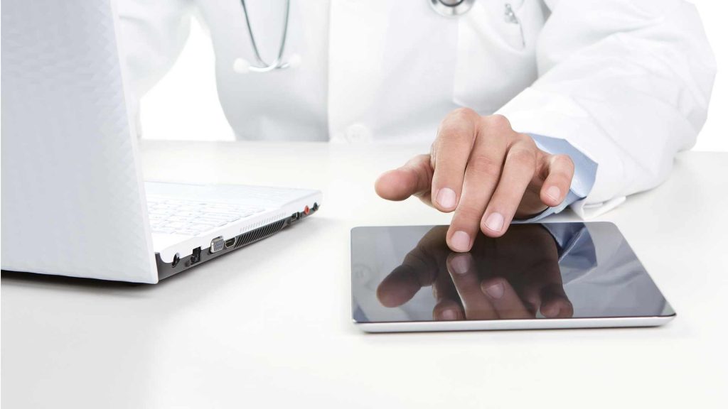 Doctor Using Desktop and Tablet